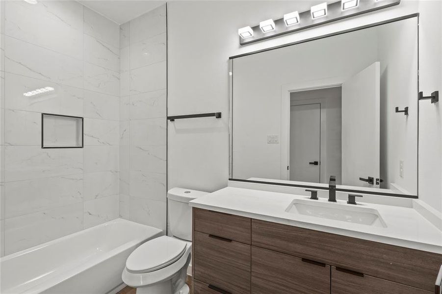 Full bathroom with vanity, toilet, and tiled shower / bath