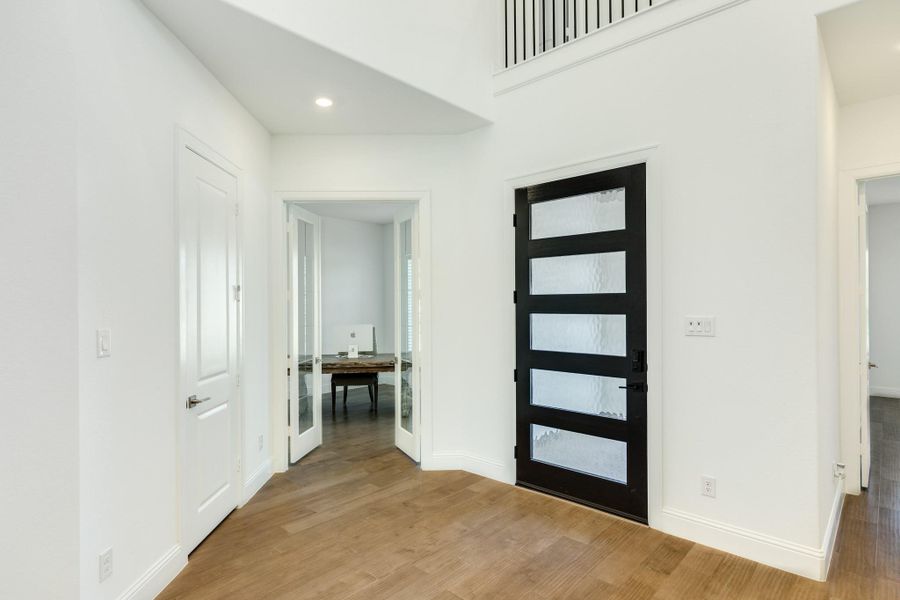 Upon entering the residence, the foyer leads to a private, spacious office situated to the right. Featuring street-facing windows and expansive 10-foot glass doors, this room is flooded with natural light, creating an ideal environment for remote work.