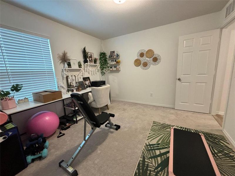 Workout room featuring light colored carpet and baseboards