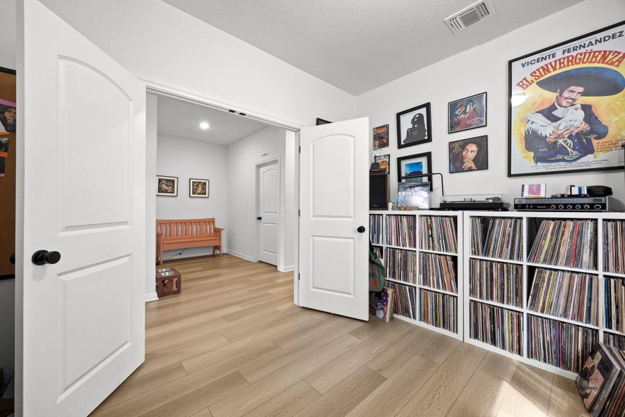 Light wood-finish flooring extends through an interior space featuring white walls and a white ceiling