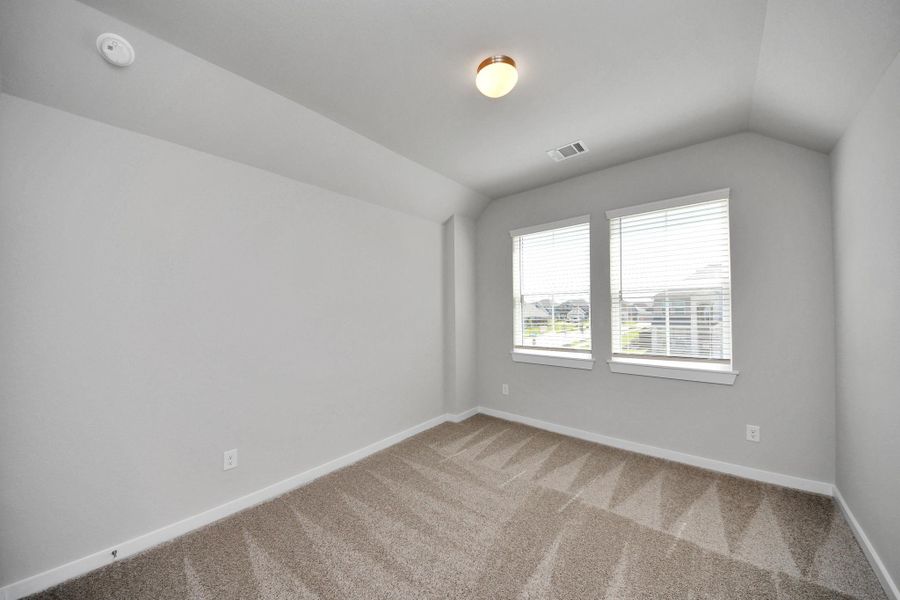 Secondary bedroom features plush carpeting, large windows that let in plenty of natural light, bright paint, and spacious closets. Sample photo of completed home with similar floor plan. Actual colors and selections may vary. Secondary bedroom features plush carpeting, large windows that let in plenty of natural light, bright paint, and spacious closets. Sample photo of completed home with similar floor plan. Actual colors and selections may vary.