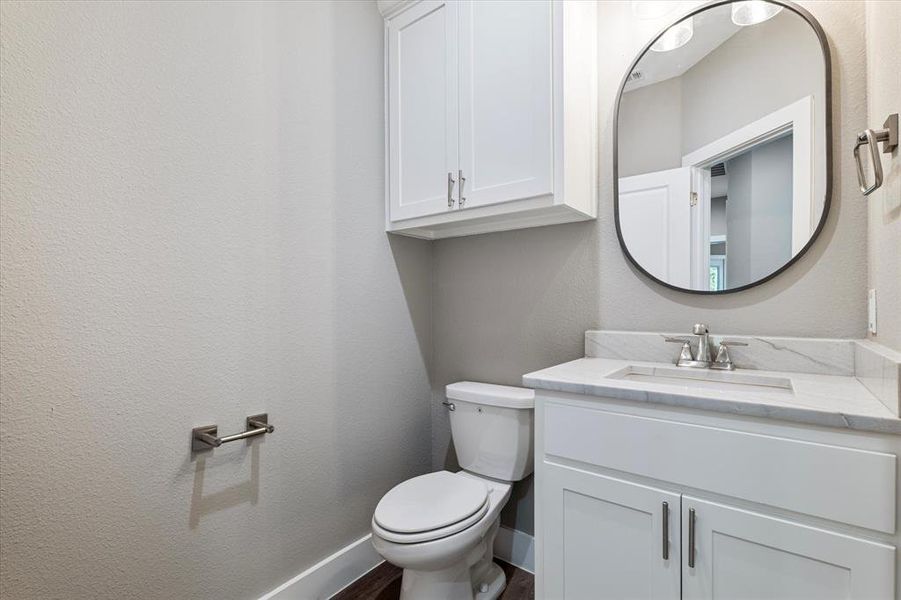 Bathroom with vanity, hardwood / wood-style floors, and toilet Bathroom with vanity, hardwood / wood-style floors, and toilet