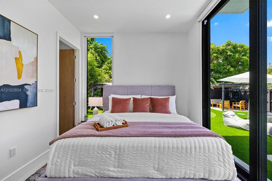 Floor-to-ceiling glass sliding doors, tall vertical window, and recessed ceiling lighting