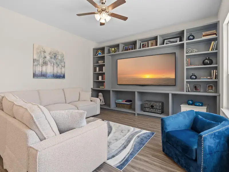 The living room space in the Portico C features an expansive, light-filled area with large windows and a versatile layout perfect for both entertaining and everyday living. Image depicts home as-is virtually staged.