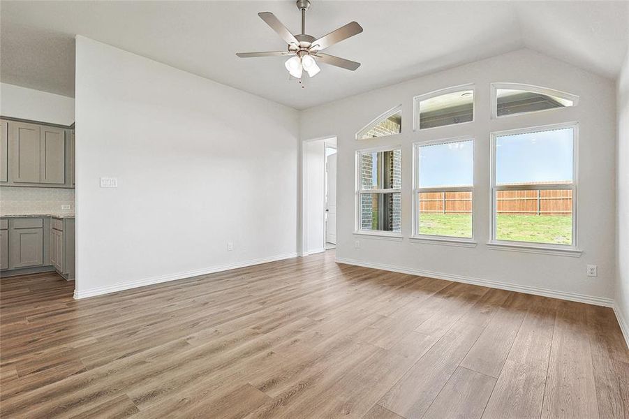 Unfurnished living room with ceiling fan, lofted ceiling, and light hardwood / wood-style flooring