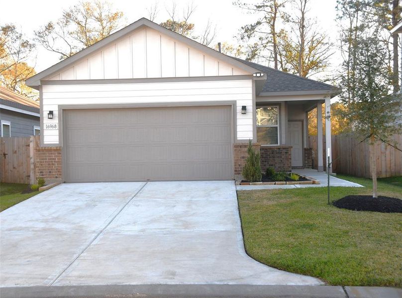 This is a charming one-story home with a modern façade, featuring a two-car garage and a neatly landscaped front yard. The exterior combines brick and siding, offering a clean and welcoming appearance.