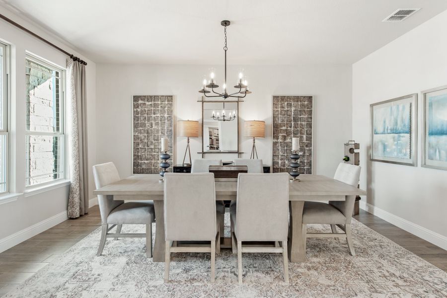 Dining room with gray wood table, six upholstered chairs, chandelier, and hardwood floors Dining room with gray wood table, six upholstered chairs, chandelier, and hardwood floors