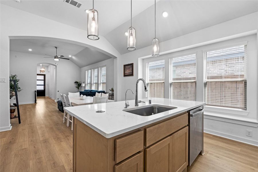 Modern kitchen 0pens into a cozy living area with wood flooring, creating a bright and inviting space. Modern kitchen 0pens into a cozy living area with wood flooring, creating a bright and inviting space.