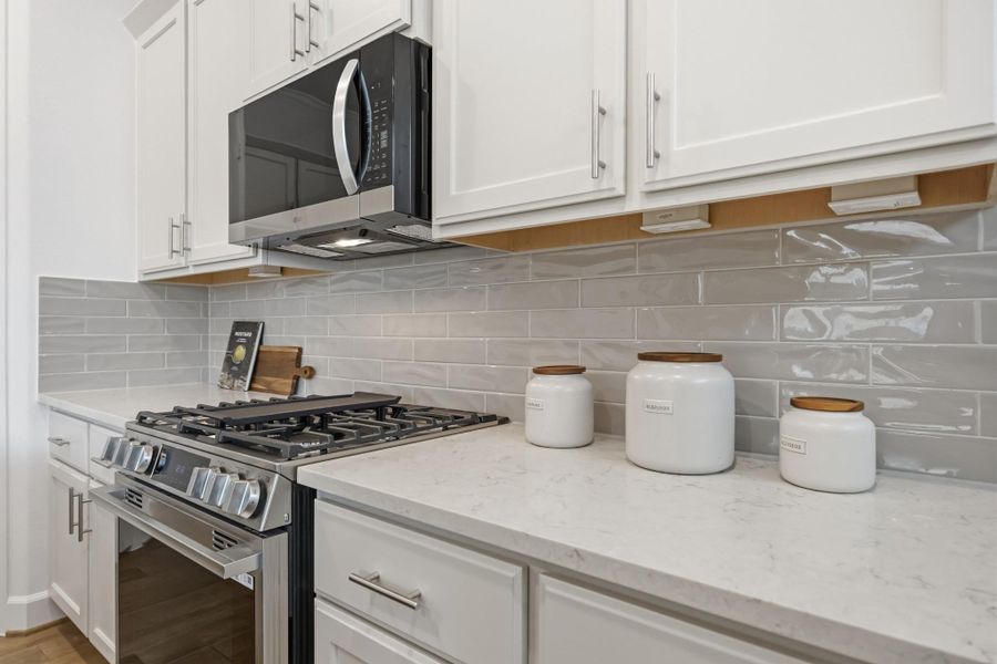 Timeless Functionality: The heart of the home shines with a single-bay undermount sink, sleek gooseneck faucet, and polished quartz countertops—paired with custom cabinets adorned with elegant hardware for a refined yet functional touch.