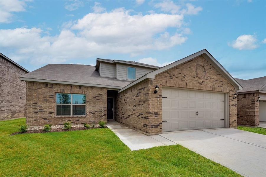 View of front of property featuring a garage and a front yard