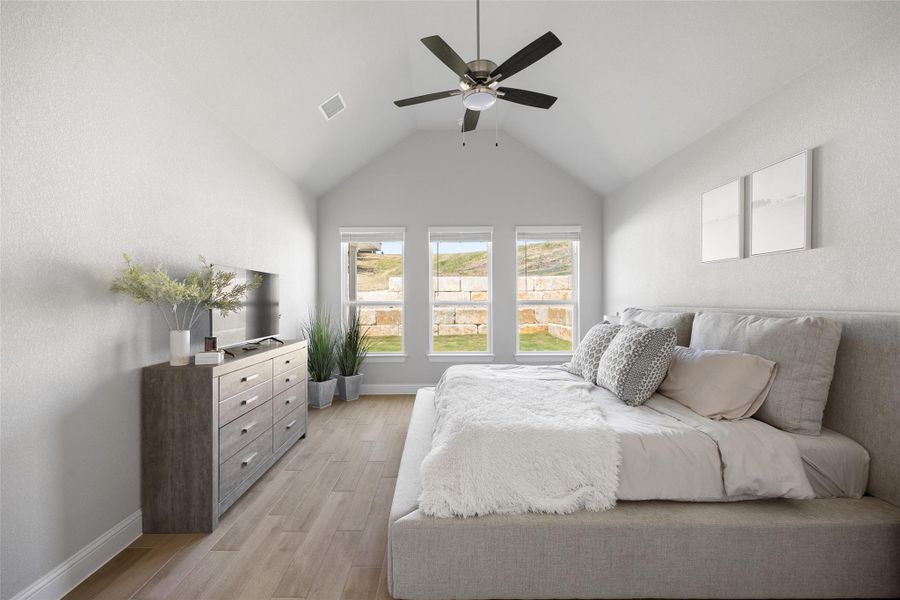 Serene and spacious, the primary suite showcases wood-look tile flooring, a ceiling fan, window blinds, and picturesque views of the outdoor oasis—your perfect private retreat.