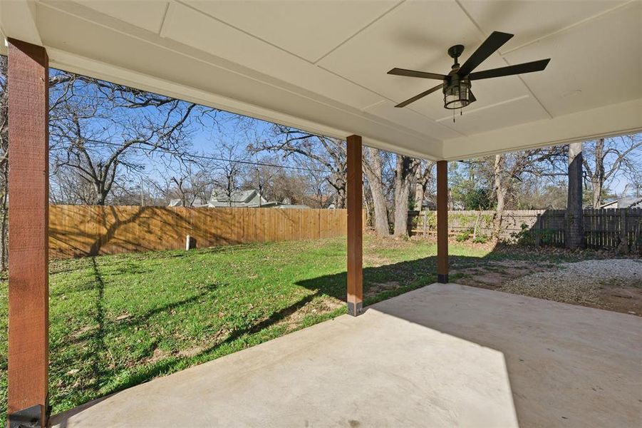 Fenced backyard featuring a ceiling fan and a patio Fenced backyard featuring a ceiling fan and a patio