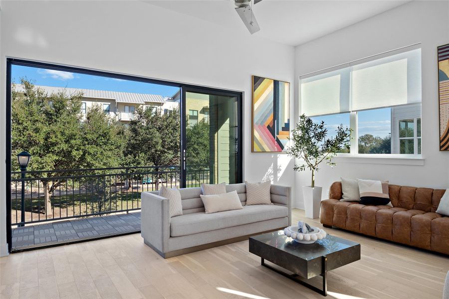 Light wood-finish flooring complements white walls in this open-concept room