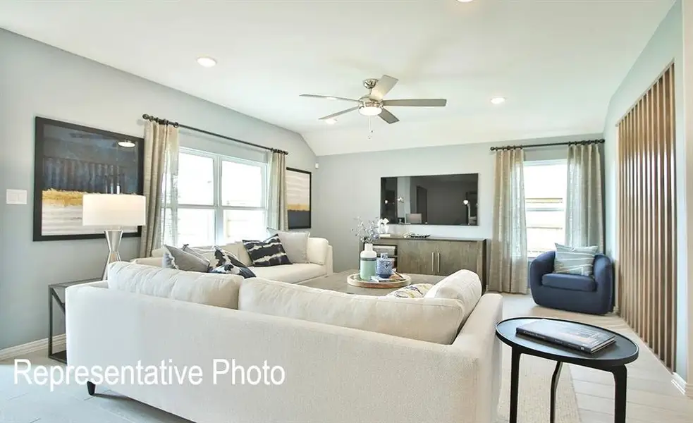 Bright living space featuring a ceiling fan, recessed lighting, and large windows with drapery