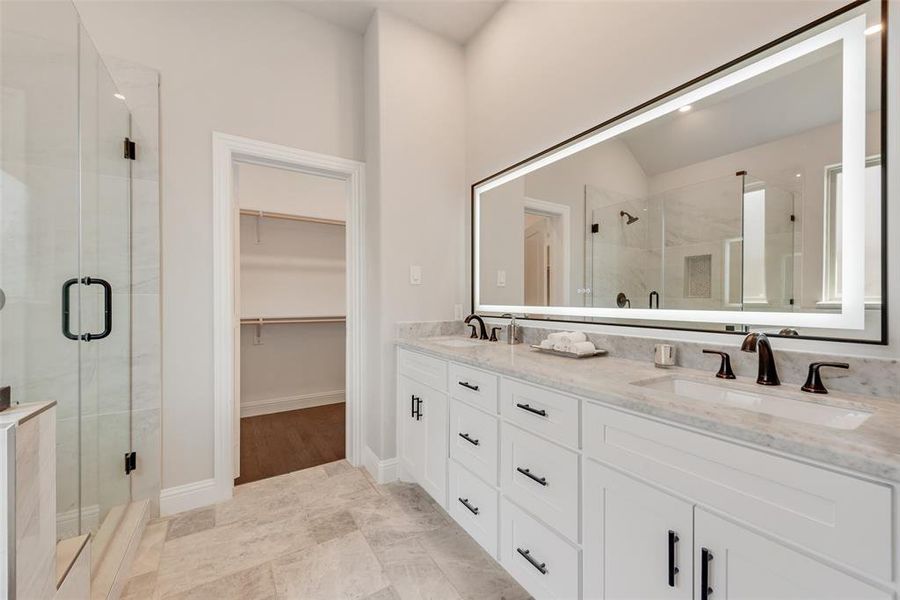 Full bath with a stall shower, double vanity, and a spacious closet Full bath with a stall shower, double vanity, and a spacious closet