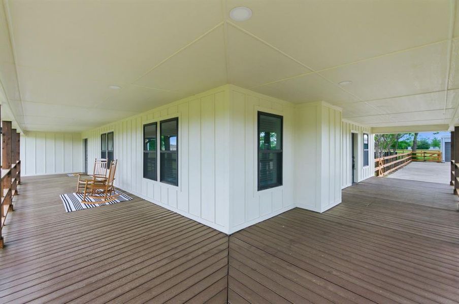 Expansive covered deck with recessed lighting, dark wood flooring, and white exterior siding Expansive covered deck with recessed lighting, dark wood flooring, and white exterior siding