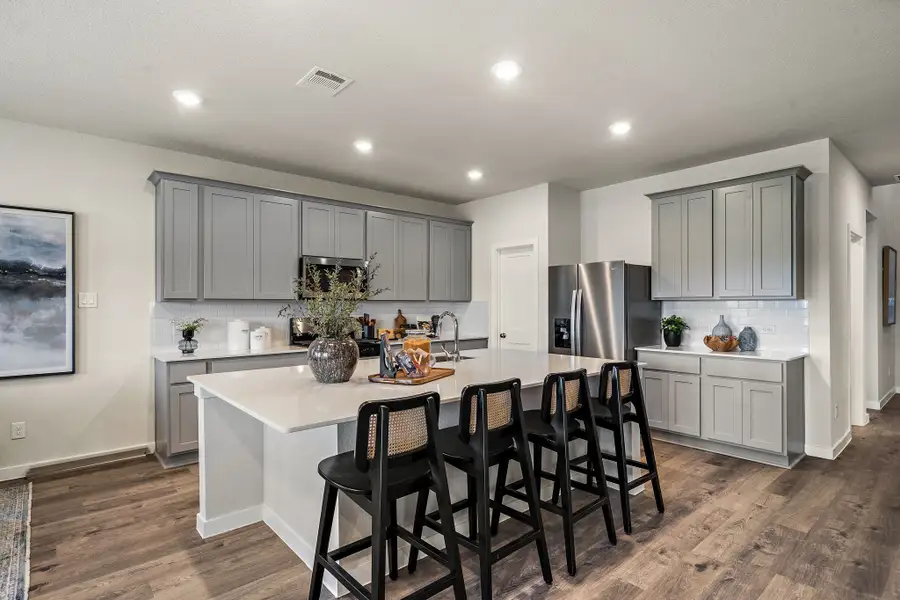 A kitchen with a dining table and chairs.