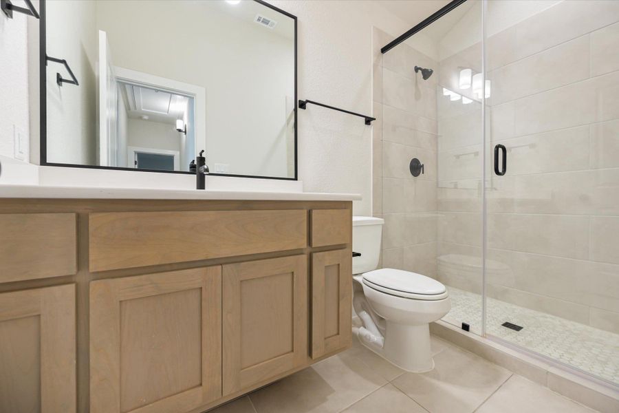A chic bathroom features a sleek vanity and a spacious, clear glass shower enclosure.