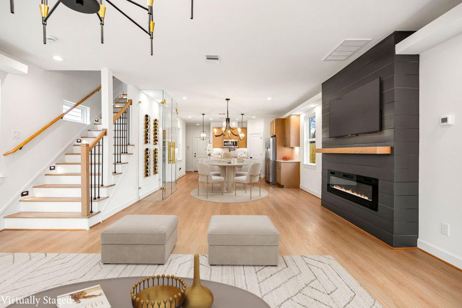 An inviting open-concept living space highlights clean architectural lines, warm flooring, and seamless flow between levels. The modern staircase and thoughtful layout create a striking first impression while offering both style and everyday functionality.