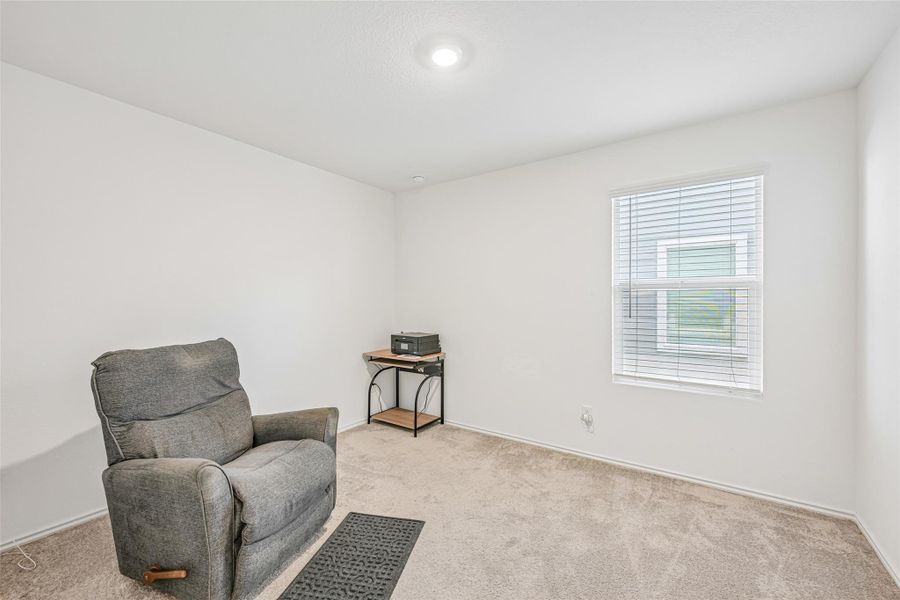 Carpeted interior space with a single window featuring horizontal blinds Carpeted interior space with a single window featuring horizontal blinds