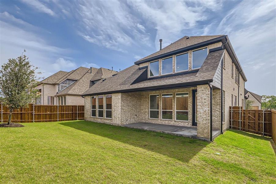 Back of property featuring a patio and a lawn