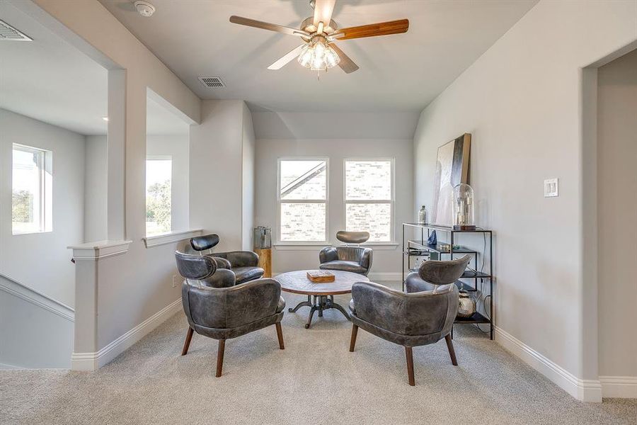 Sitting room with light colored carpet and ceiling fan