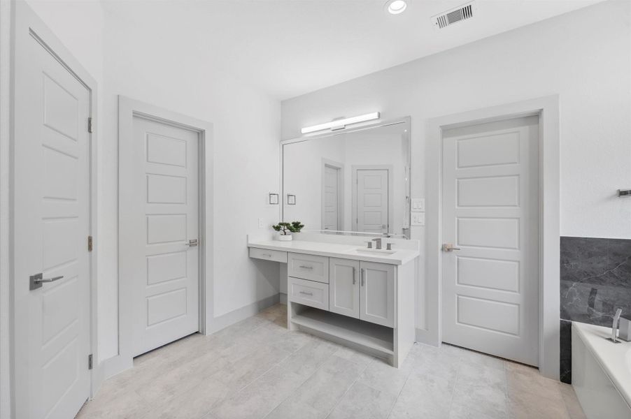 Bright and modern bathroom featuring a large mirror above a sleek vanity, neutral tones, ample lighting, and a separate shower area. Bright and modern bathroom featuring a large mirror above a sleek vanity, neutral tones, ample lighting, and a separate shower area.
