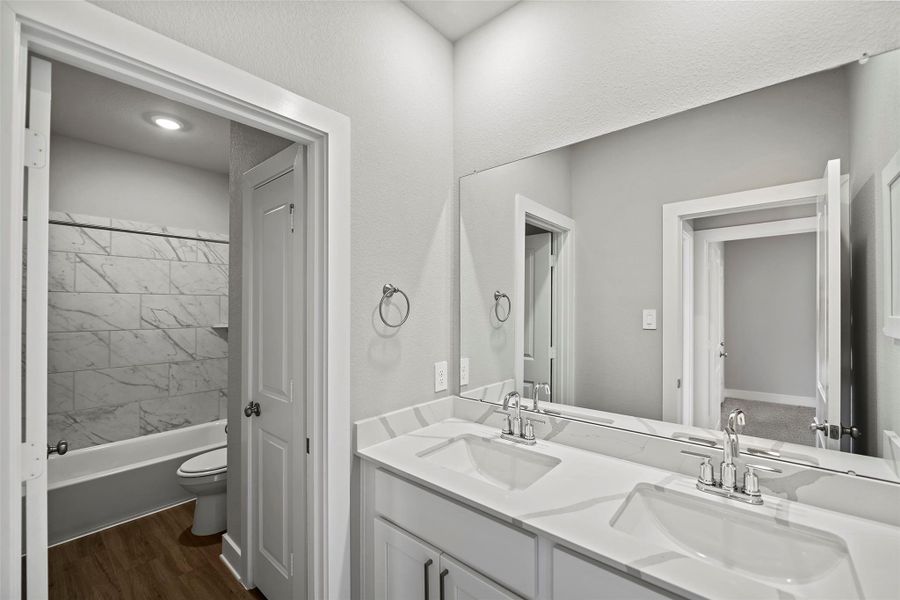 Well-appointed baths with modern fixtures, quartz countertops, and stylish tile accents.