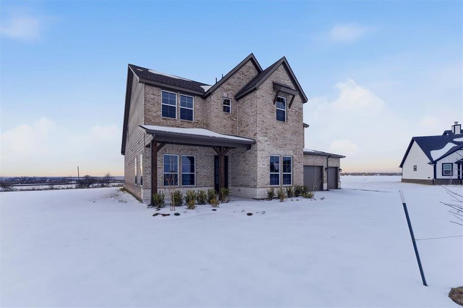 View of front of property featuring brick siding and a garage