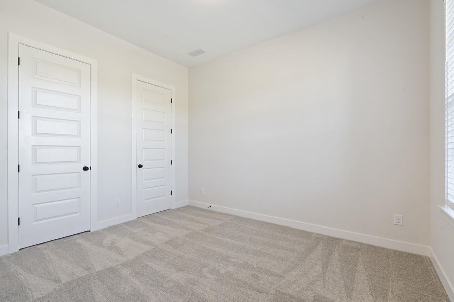 Neutral-toned carpeting, five-panel interior doors, and a window with blinds