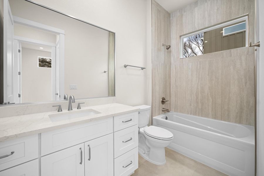 A full bathroom in the main floor features a soaking tub, quartz countertops and Tiled shower combo.