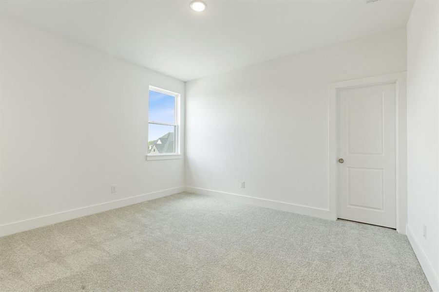 Neutral-toned carpeting defining a spacious room with white walls and trim Neutral-toned carpeting defining a spacious room with white walls and trim
