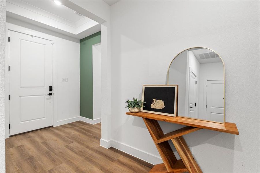 Foyer with baseboards and wood finished floors