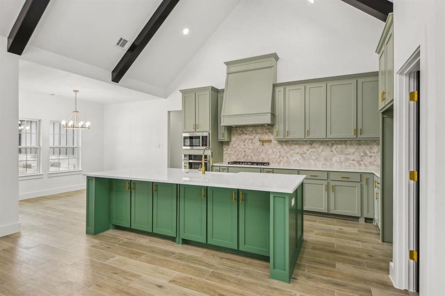 Kitchen with green cabinets, tasteful backsplash, beamed ceiling, wood tiled floors, and high vaulted ceiling Kitchen with green cabinets, tasteful backsplash, beamed ceiling, wood tiled floors, and high vaulted ceiling