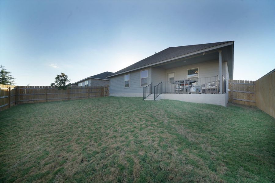 Rear view of property with a fenced backyard, a patio, and a shingled roof