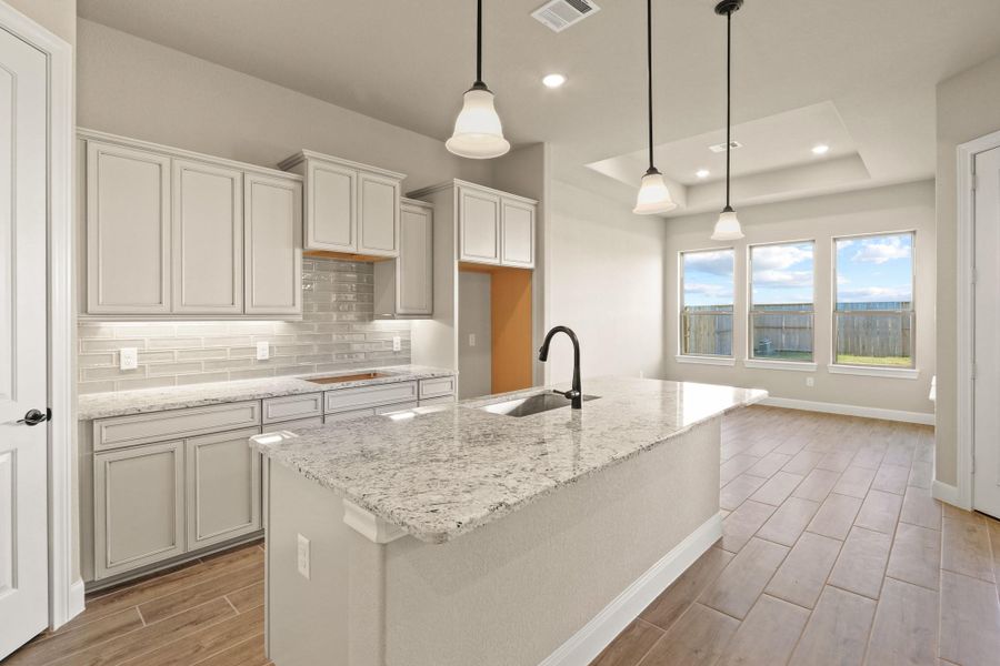 Your chef-inspired kitchen is ready to impress! This beautifully designed space boasts gleaming granite countertops with coordinating tile backsplash. The rich cabinetry is perfectly complemented by under-cabinet lighting and recessed lighting, creating a bright and inviting ambiance. At the heart of it all, a sprawling island with breakfast bar seating offers the perfect spot for casual dining and entertaining. Your chef-inspired kitchen is ready to impress! This beautifully designed space boasts gleaming granite countertops with coordinating tile backsplash. The rich cabinetry is perfectly complemented by under-cabinet lighting and recessed lighting, creating a bright and inviting ambiance. At the heart of it all, a sprawling island with breakfast bar seating offers the perfect spot for casual dining and entertaining.