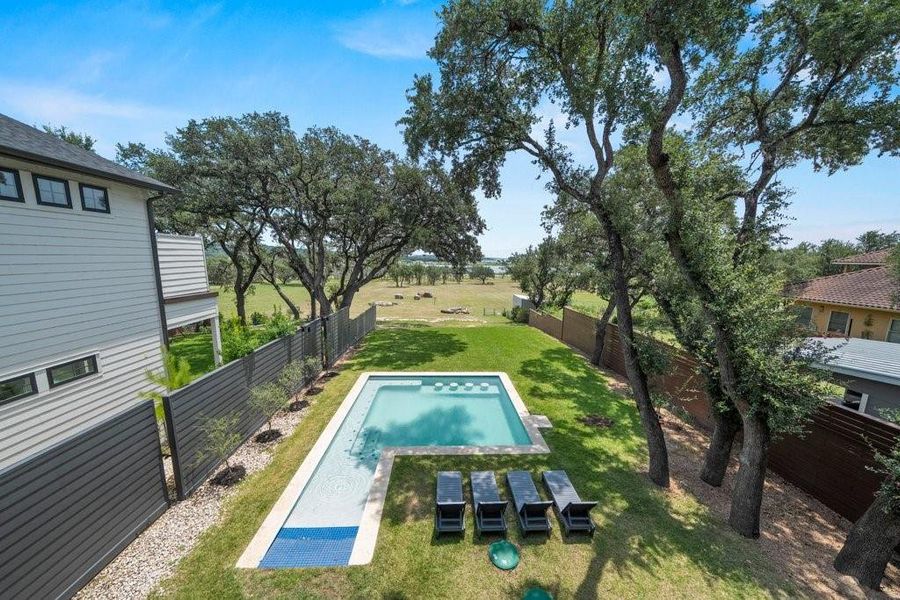 The beautifully designed outdoor living area features a sparkling pool, mature oak trees, and peaceful open views, creating a private backyard retreat perfect for relaxing or entertaining year-round. The beautifully designed outdoor living area features a sparkling pool, mature oak trees, and peaceful open views, creating a private backyard retreat perfect for relaxing or entertaining year-round.