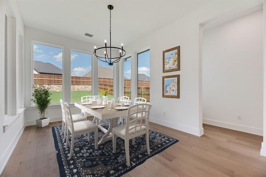 Dining room with light wood-style floors and a chandelier