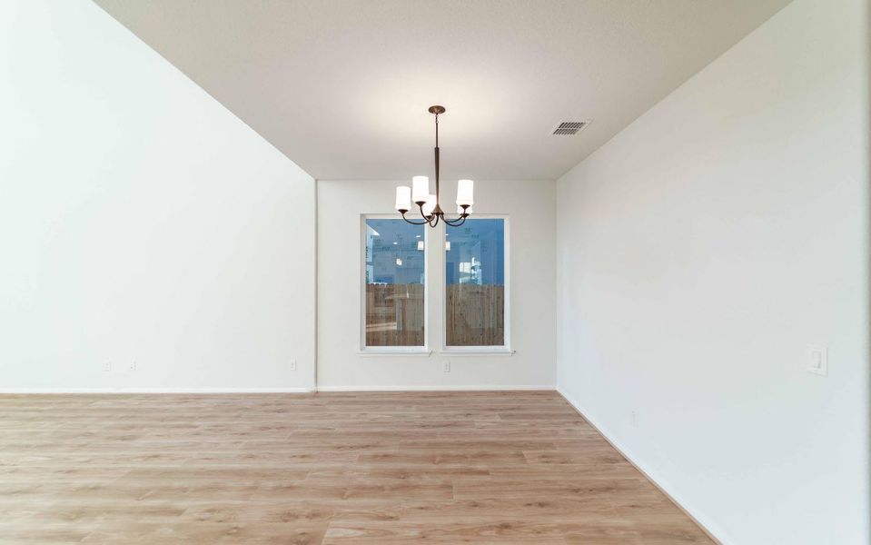 Unfurnished dining area featuring a chandelier and light wood-type flooring