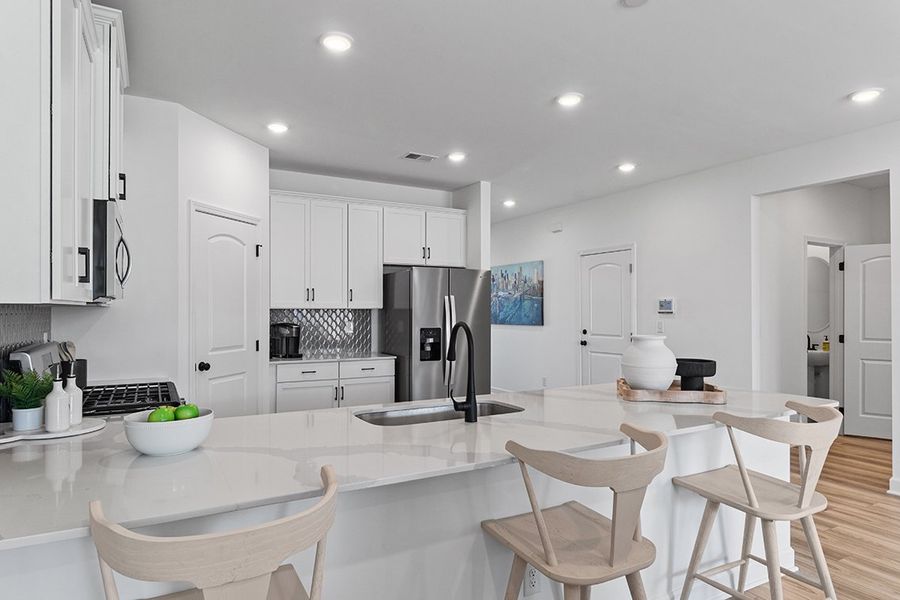 A kitchen with white cabinets.