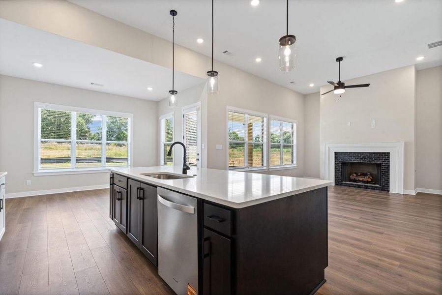 Central kitchen island featuring a stainless steel sink, black faucet, and white countertop Central kitchen island featuring a stainless steel sink, black faucet, and white countertop