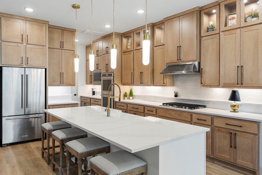 The oversized island offers generous workspace and additional seating, creating a perfect gathering spot in the heart of the kitchen.