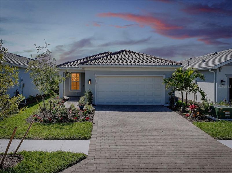 Front exterior of a new home in BeachWalk by Manasota Key, Englewood, FL, highlighting curb appeal (Image 24).