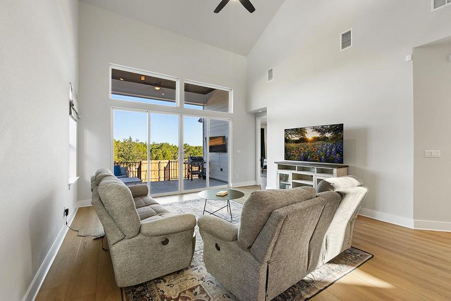 High vaulted ceilings and glass sliding doors frame serene green views from this airy living area.