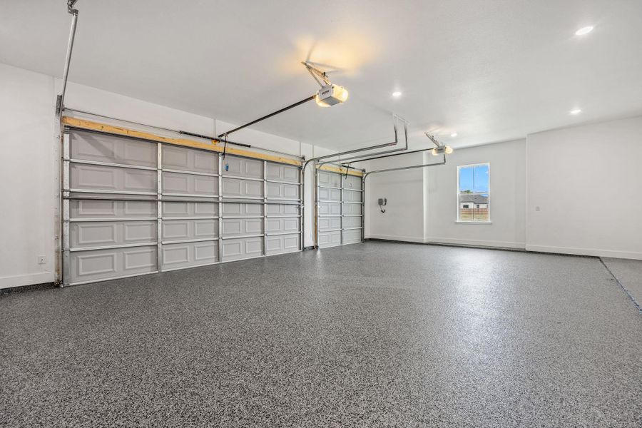 Garage featuring baseboards and a garage door opener