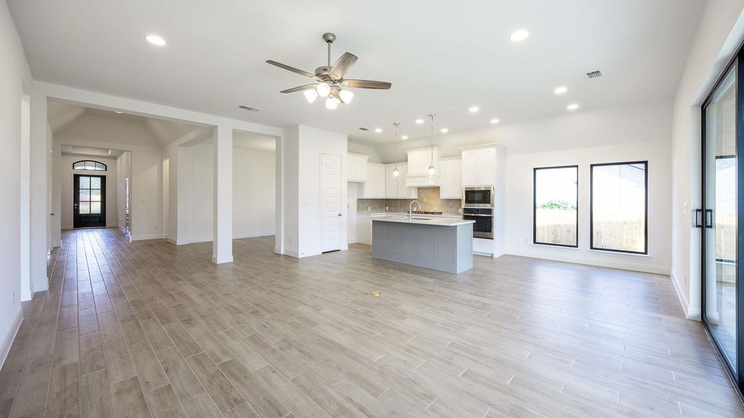 Unfurnished living room with recessed lighting, ceiling fan, and light wood finished floors Unfurnished living room with recessed lighting, ceiling fan, and light wood finished floors