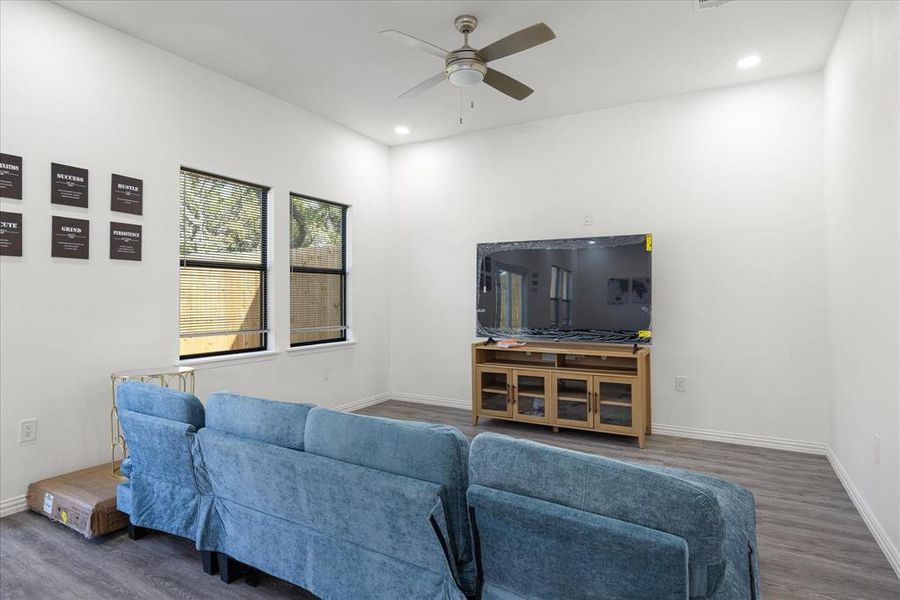 Living room with dark hardwood / wood-style floors and ceiling fan