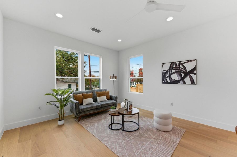 Sitting room with light wood-style floors and recessed lighting
