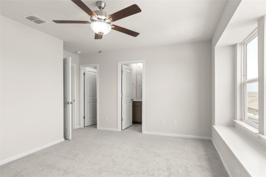 Unfurnished bedroom with light colored carpet, a ceiling fan, and ensuite bathroom Unfurnished bedroom with light colored carpet, a ceiling fan, and ensuite bathroom