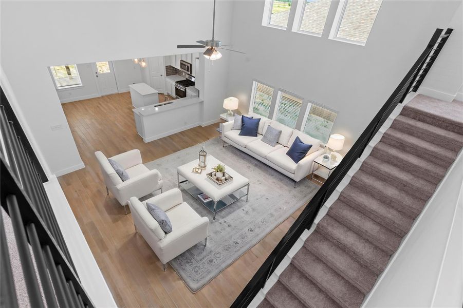 Virtually staged to highlight the potential, this aerial view of the living space shows off the home’s scale and architectural drama—from the two-story windows to the open-concept layout below. Virtually staged to highlight the potential, this aerial view of the living space shows off the home’s scale and architectural drama—from the two-story windows to the open-concept layout below.
